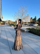 Vestido largo de animal print con cuello redondo, mangas largas abullonadas y falda escalonada.