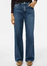 Pantalón wide leg de cintura media en denim azul con lavado clásico, corte holgado y bolsillos laterales y traseros.