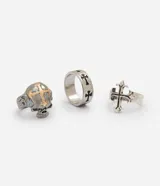 Kit de tres anillos masculinos de metal con acabado envejecido y diseños inspirados en el estilo urbano y alternativo, incluyendo calavera en relieve, cruz aplicada y cruces grabadas.