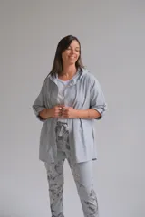 Campera de gabardina color celeste, con capucha, cierre frontal completo y mangas tres cuartos con detalle de trabilla.