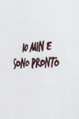 Remera blanca de corte oversize con cuello redondo y mangas cortas. Presenta un pequeño bordado en el pecho con texto en color oscuro.