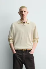 Polo de punto regular fit color celeste, tejido con mezcla de cáñamo y algodón. Presenta cuello tipo solapa con abertura frontal y manga larga, con terminaciones en rib.