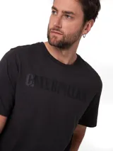 Remera negra de jersey con cuello redondo y mangas cortas. Presenta el logotipo de Caterpillar impreso en el pecho en tono oscuro.