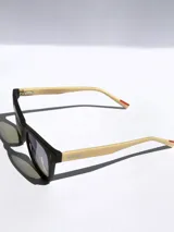 Lentes de sol con armazón bicolor, frente negro y patillas en tono beige con detalle de marca grabado. Cuentan con cristales polarizados con protección UV 400.