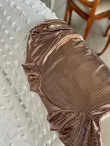 Polera de manga larga color cobre con efecto brillante y frunces en los hombros, cuello alto y caída recta.