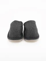 Pantuflas cerradas de estilo clásico, color gris con textura tejida en la parte superior e interior forrado en piel sintética suave. Cuenta con suela de goma y etiqueta de la marca Grego en la plantilla.
