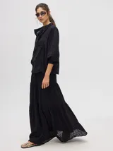 Camisa de broderie de algodón color negro, con diseño de calados, cuello mao con cierre de botones, mangas abullonadas con puños fruncidos y detalles de galones con transparencias.