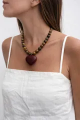 Collar de cuentas esféricas de piedra ojo de tigre con dije central en forma de corazón de madera pulida en tono rojizo.