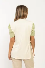 Chaleco color beige de tela tipo gamuza, con cuello alto y lazos en ambos laterales.