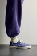 Zapatilla baja de cordones de Fruit of the Loom x Zara, confeccionada en tejido de algodón morado con detalles en tono burdeos y suela de goma blanca con volumen.