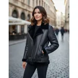 Campera estilo biker confeccionada en gamulán negro con forro interior de corderito. Presenta cierre asimétrico, bolsillos laterales con cierre y cinturón ajustable en la cintura.