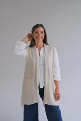 Chaleco largo abierto de tejido de punto color crudo, con bolsillos frontales aplicados y diseño sin mangas.