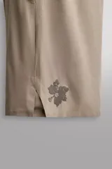 Short deportivo Zara Athleticz modelo Boulder 9", color beige, confeccionado en tejido técnico ligero y elástico. Cuenta con cintura elástica ajustable con cordón interior, bolsillos frontales y aberturas laterales en el bajo.