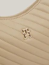 Cartera de hombro color beige con textura acolchada en diagonal y logo metálico dorado de Tommy Hilfiger. Tiene asa superior, correa ajustable y extraíble, cierre de cremallera, bolsillo interior con cremallera y forro de poliéster.