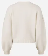 Cardigan de punto color crema con escote en V, cierre frontal de botones y mangas largas abullonadas con puños acanalados. Presenta un diseño corto y ajuste cómodo.