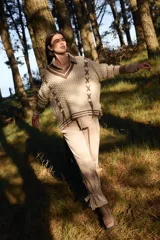 Pantalón de terciopelo en tono beige, de corte holgado y diseño tipo jogger con detalle de lazos ajustables en los tobillos.
