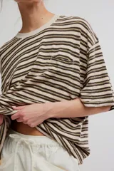 Remera oversize de manga corta a rayas celestes y blancas, con cuello redondo y un bolsillo aplicado en el pecho.