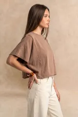 Remera oversize de algodón blanco crudo, con cuello redondo y mangas cortas anchas de corte relajado.