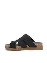 Sandalia tipo slide de color negro con diseño de tiras cruzadas y hebilla metálica ajustable. Presenta una textura grabada tipo reptil en la capellada, plantilla anatómica con borde de corcho y suela de goma plana.