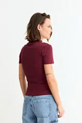 Remera de manga corta con cuello media polera, confeccionada en tejido acanalado al cuerpo.