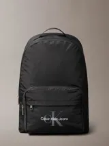 Mochila negra de poliéster reciclado con compartimento para laptop, bolsillo exterior con cremallera y logo de Calvin Klein Jeans en el frontal.