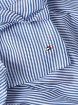 Blusa sin mangas con cuello camisero, diseño cruzado con lazo en la cintura y estampado a rayas verticales azules y blancas.