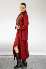 Pollera midi de corte irregular con diseño de estampado cuadrillé en tonos rojo y negro. Presenta un acabado con flecos en el borde y una abertura lateral que deja ver la pierna.