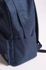 Mochila azul con logo bordado, bolsillos externos y bolsillo escondido al dorso con cierre.