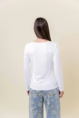 Remera básica de manga larga en color blanco, confeccionada en tela gruesa con elastano. Presenta un diseño liso con escote redondo y un calce cómodo que se adapta al cuerpo sin ajustar.