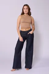 Jean de corte wide leg y tiro bajo, color azul oscuro, con costuras laterales desplazadas hacia el frente y cierre frontal con botón.