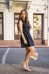 Vestido corto negro sin mangas, de corte recto y falda evasé.