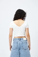 Top negro de algodón con mezcla de poliéster y elastano, con escote en V delantero y trasero.