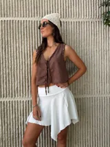 Mini pollera blanca de tela liviana con corte irregular y diseño con picos asimétricos.