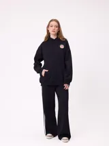 Canguro gris con capucha, de corte oversize, con estampado gráfico multicolor en la espalda que incluye diversos parches y logotipos de la marca Rusty.