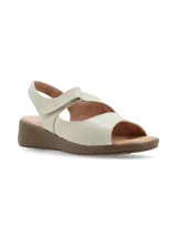 Sandalias de cuero color crudo con tiras cruzadas, cierre de velcro en el empeine, taco con plataforma baja de color marrón y suela de goma.