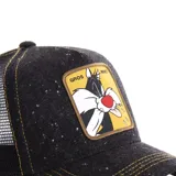Gorra tipo trucker de color negro con efecto jaspeado, con parche frontal cuadrado que presenta al personaje Silvestre de Looney Tunes sobre fondo amarillo. Cuenta con costuras en contraste y malla trasera.