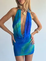 Vestido corto de microtul azul con efecto degradado o a cuadros en tonos azules y verdosos. Diseño halter con escote profundo.