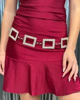 Cinturón de cadena compuesto por eslabones cuadrados rígidos decorados con strass brillante, unidos por pequeñas argollas metálicas.