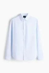 Camisa de corte entallado con cuello inglés, canesú en la espalda y mangas largas con puños ajustables. Presenta un diseño de rayas verticales finas y un bajo levemente redondeado.