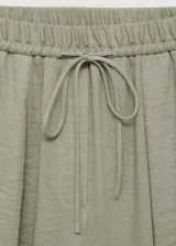 Pantalón largo de tiro alto color verde, con cintura elástica y cordón ajustable, de diseño recto y tejido con textura.