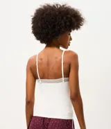 Blusa de pijama seamless color blanco de la marca Lov, confeccionada en poliamida con elastano. Presenta tirantes finos y detalle de encaje en el escote en V.