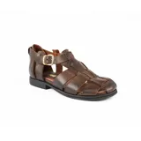 Sandalias bajas de cuero color chocolate, con tiras entrecruzadas y hebilla dorada al tobillo.