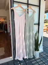 Vestido largo color rosa pálido de lino con breteles finos y escote en V. Tiene corte recto y ruedo con terminación desflecada.