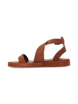 Sandalia plana de gamuza marrón chocolate, con tiras cruzadas decoradas con tachas metálicas doradas y tira ajustable al tobillo con hebilla metálica.
