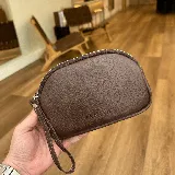 Mini sobre de cuero color marrón con cierre de cremallera y correa de mano.