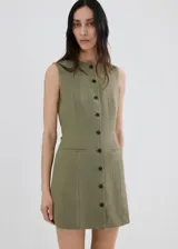Vestido corto sin mangas color verde militar, con cuello redondo y cierre frontal con botones oscuros. Presenta bolsillos de ribete en la parte delantera y un diseño de corte recto.