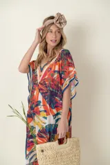 Túnica estampada con motivos de hojas en tonos naranja, blanco, azul y verde, con terminaciones en azul.