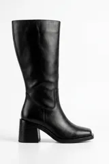 Bota de caña alta confeccionada en cuero color negro, con diseño clásico de punta cuadrada y taco ancho.