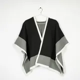 Ruana de tejido de punto con diseño bicolor en negro y gris, con bordes definidos en color blanco.