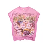 Camiseta rosada con efecto desgastado, mangas cortas y estampa frontal de múltiples rostros con la inscripción "Dont Do Drugs Its Bad" y letras en relieve con apliques de strass.